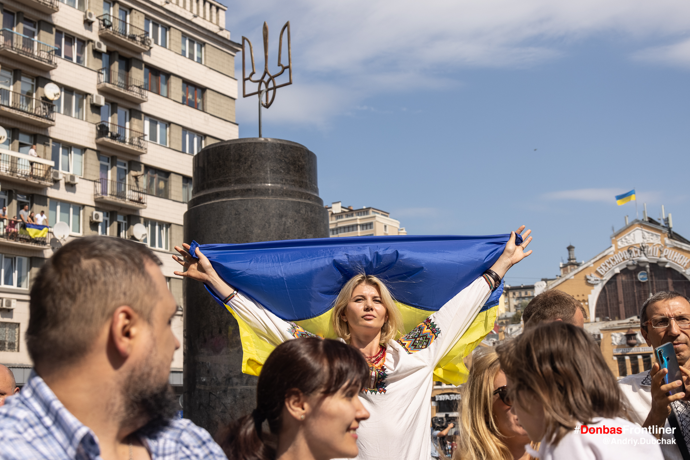 Donbas Frontliner фото - марш ветеранів 2021, жінка з прапором України біля постаменту Леніну