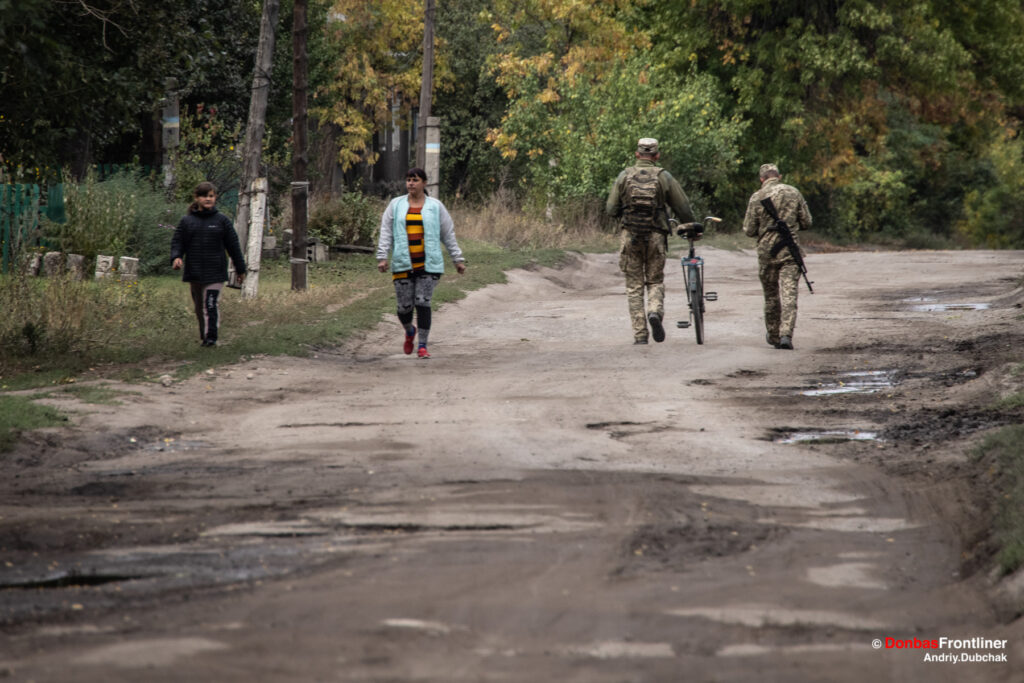Civil and Ukrainian military at the street of the frontline village Krymske, 2021 