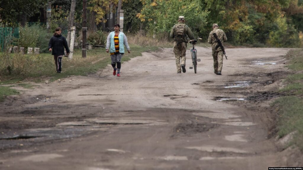 Донбас Фронтлайнер / Українські військові йдуть з позицій до магазину по вулиці Миру у фронтовому селищі Кримське, вересень 2021 року