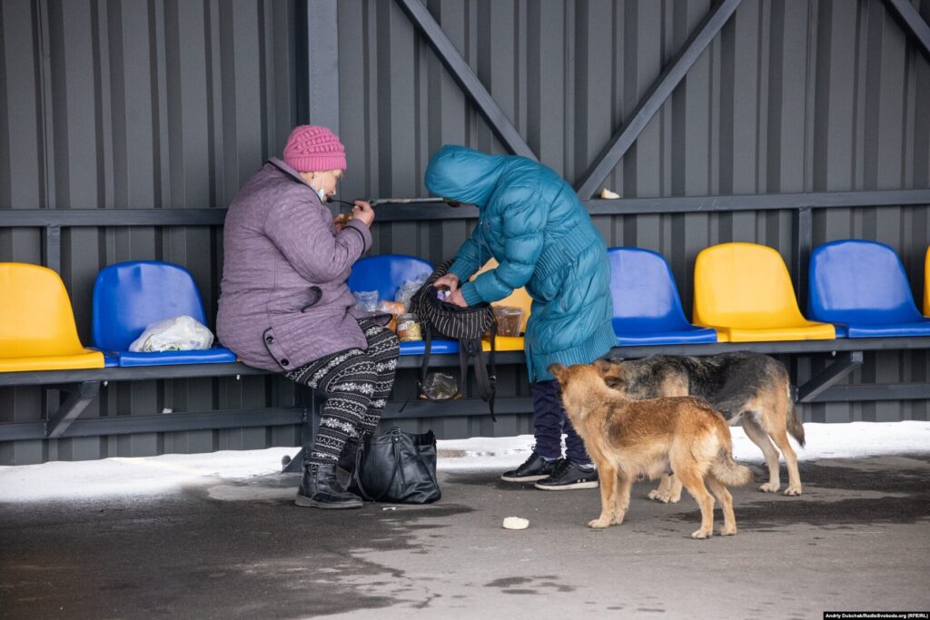 Donbas Frontliner / КПВВ Станиця Луганська. Жінки обідають на стільчиках очікуваання перед входом до КПВВ