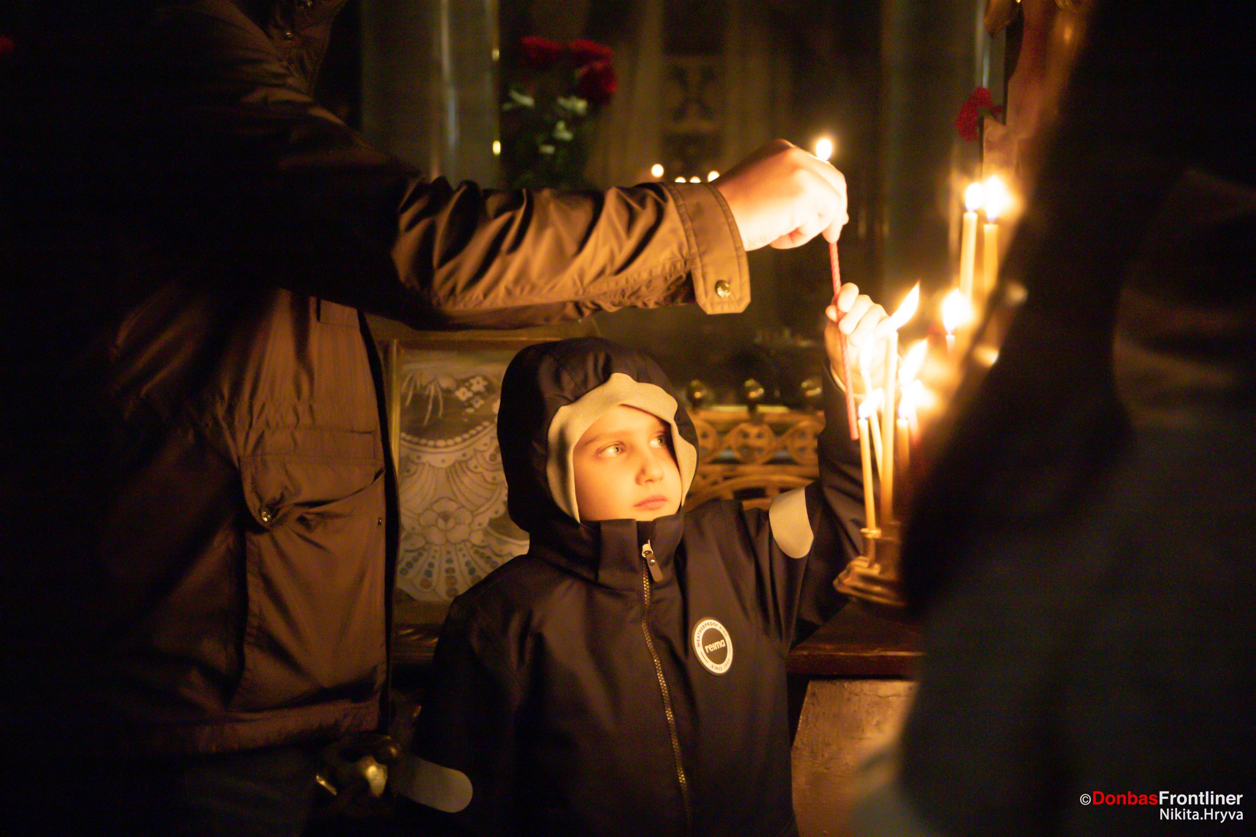 Donbas Frontliner / Володимирська церква: хлопчик запалює свічку