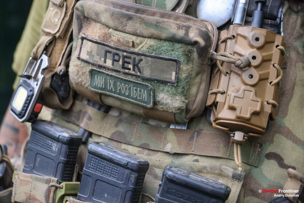 Donbas Frontliner, Ukraine war, artillery grad Partizan, Aidar battalion, soldier call-sign Grek patch. Hrek’s patch reads: “We’ll bust the fuck out of them!”