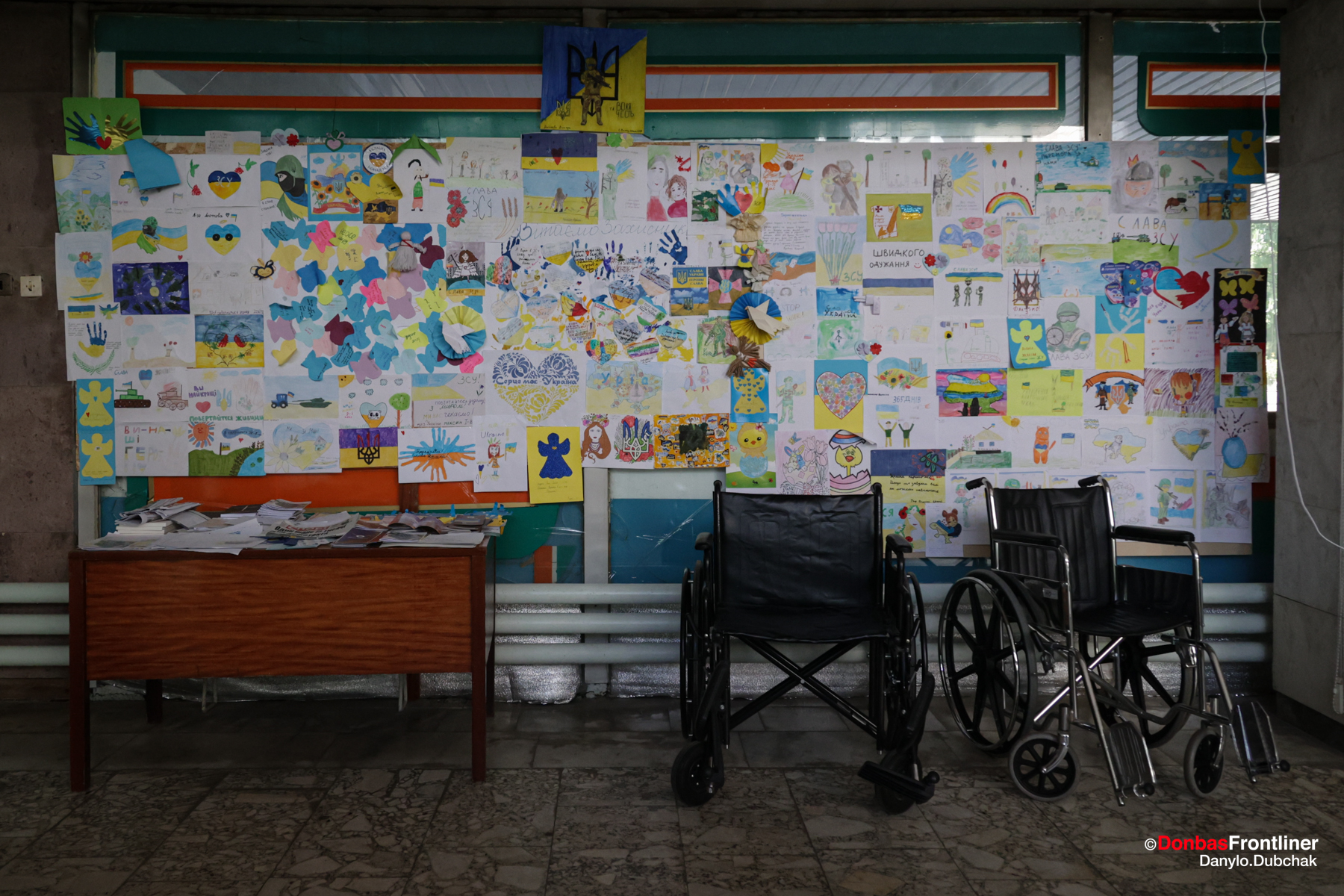 Donbas Frontliner / Інвалідні візки біля стіни, що обклеєна дитячими малюнками