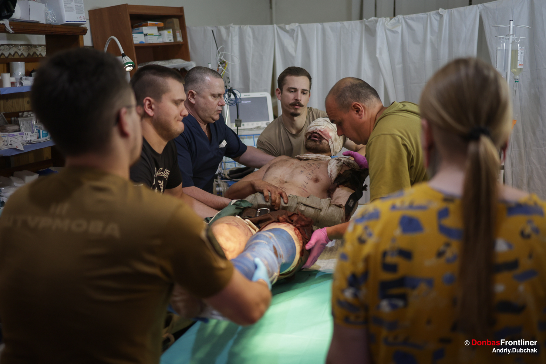 Donbas Frontliner, Військові медики перекладають на операційний стіл щойно доправленого евакуаційною машиною важкопораненого бійця.