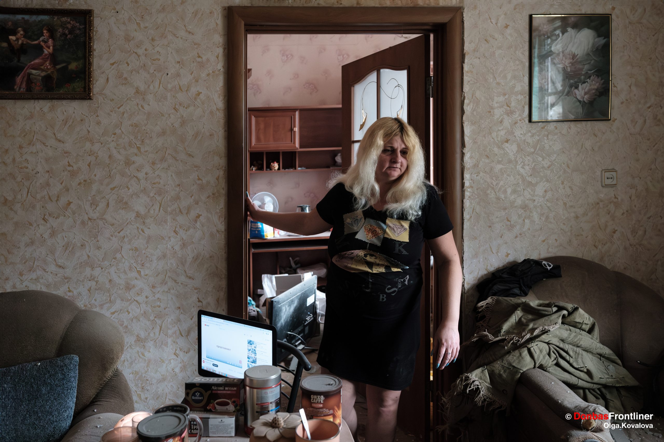 Наталія, 41-річна мешканка прифронтового міста Курахове, прибирає наслідки чергового ворожого обстрілу, який пошкодив її помешкання.