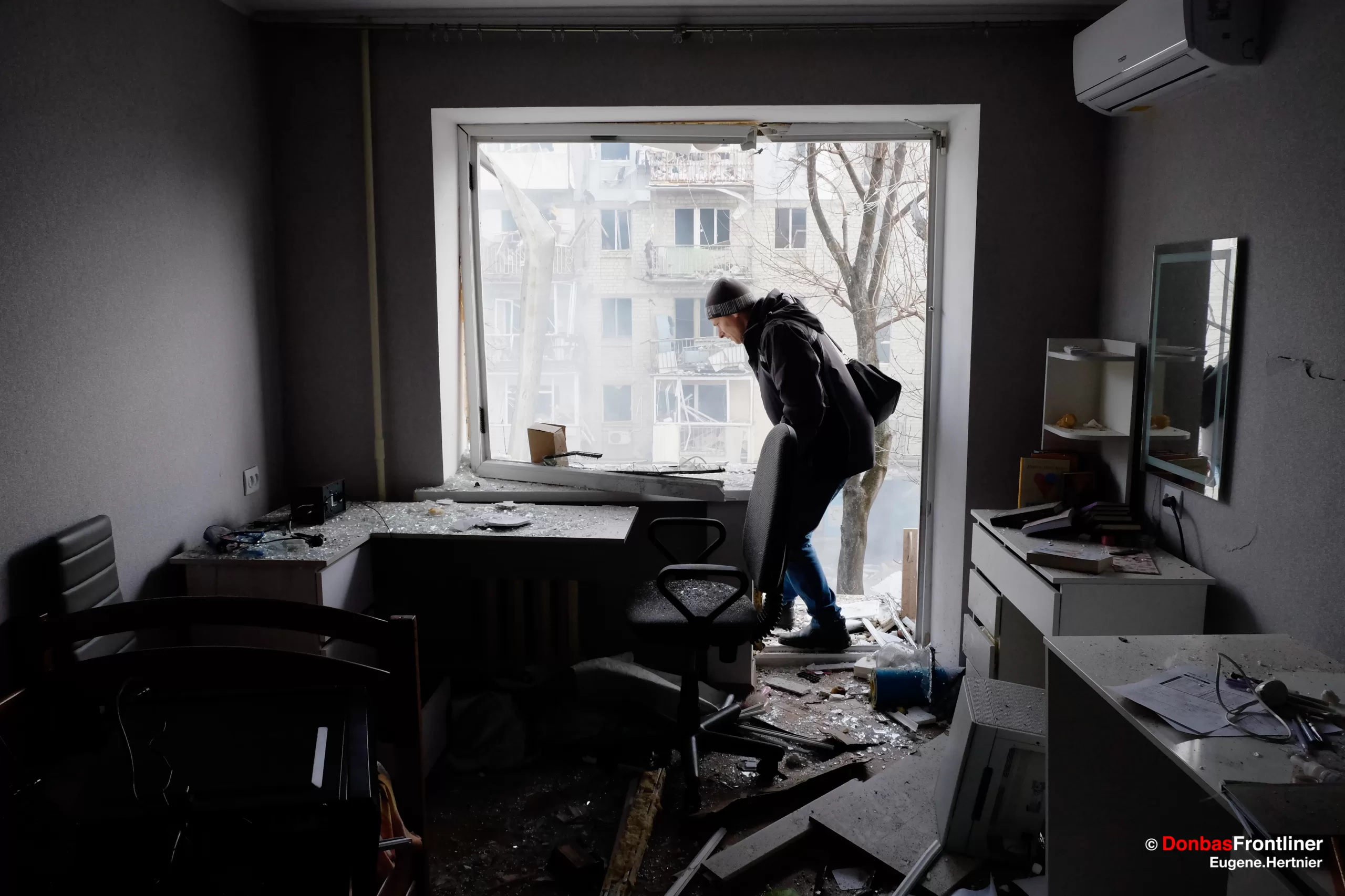 23 січня 2024. Місцеві жителі очищають свої понівечені ракетним ударом квартири поблизу селища Жуковського.
