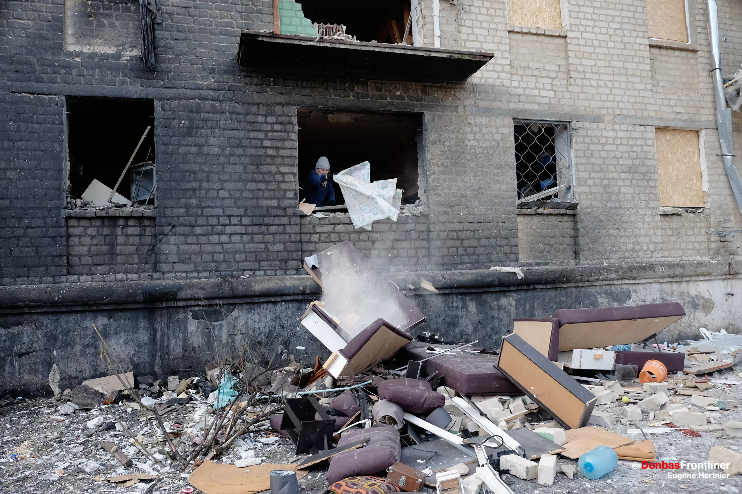 23 січня 2024. Мешканці постраждалого від ракетного удару будинку поблизу селища Жуковського очищують свої квартири від сміття та уламків.