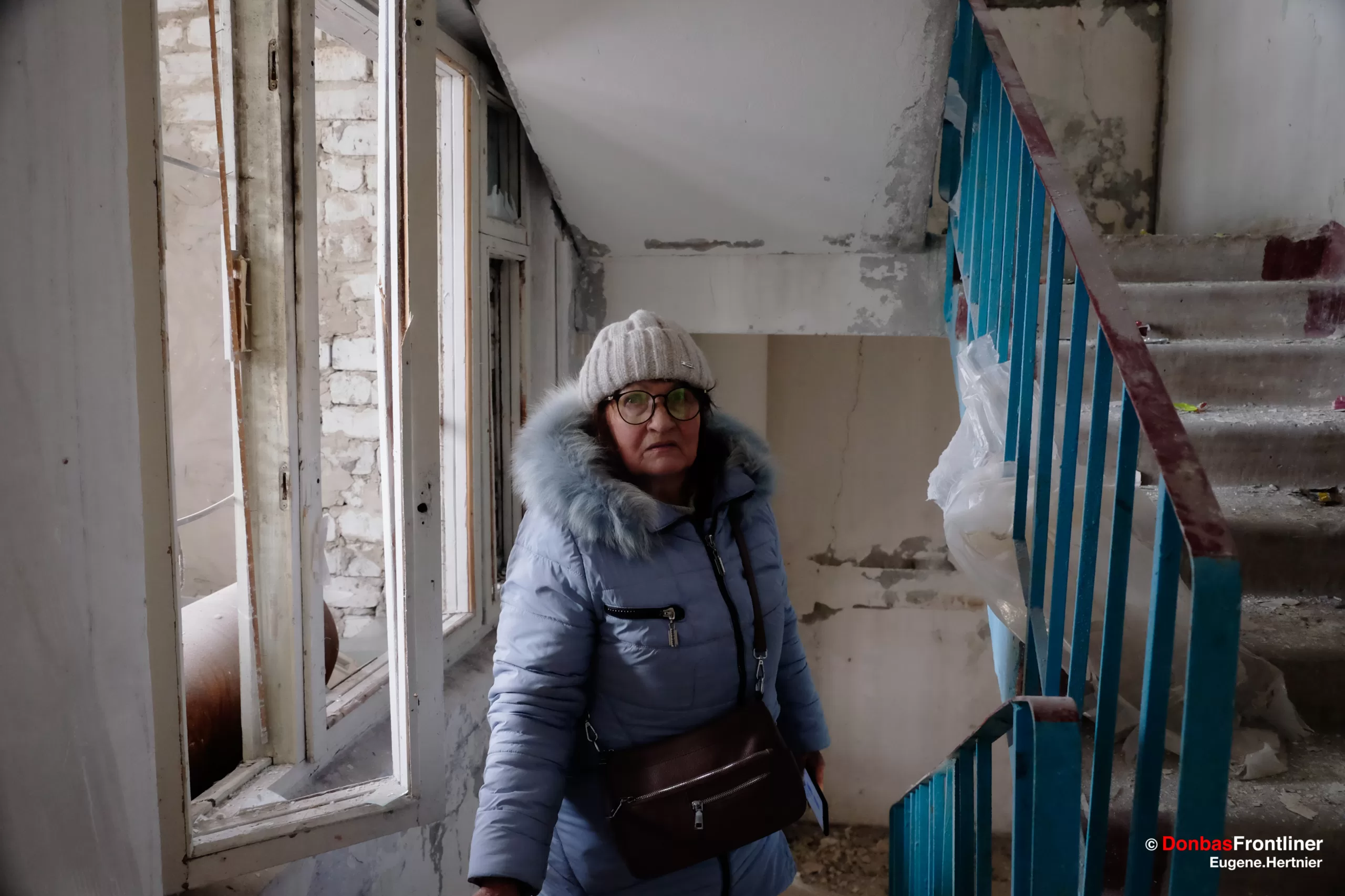 23 січня 2024. Одна з постраждалих від ракетного удару місцевих жительок підіймається сходами до своєї квартири. Харків, Україна.
