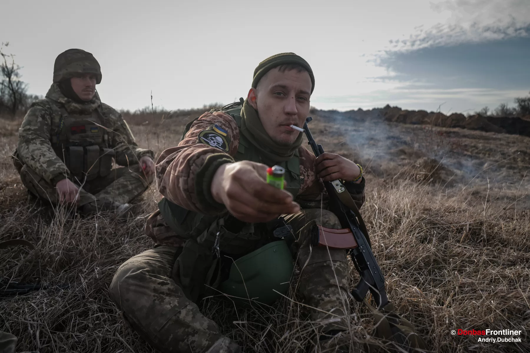 Soldier sitting in the grass, having a break, remebering Avdiivka battle and falling
