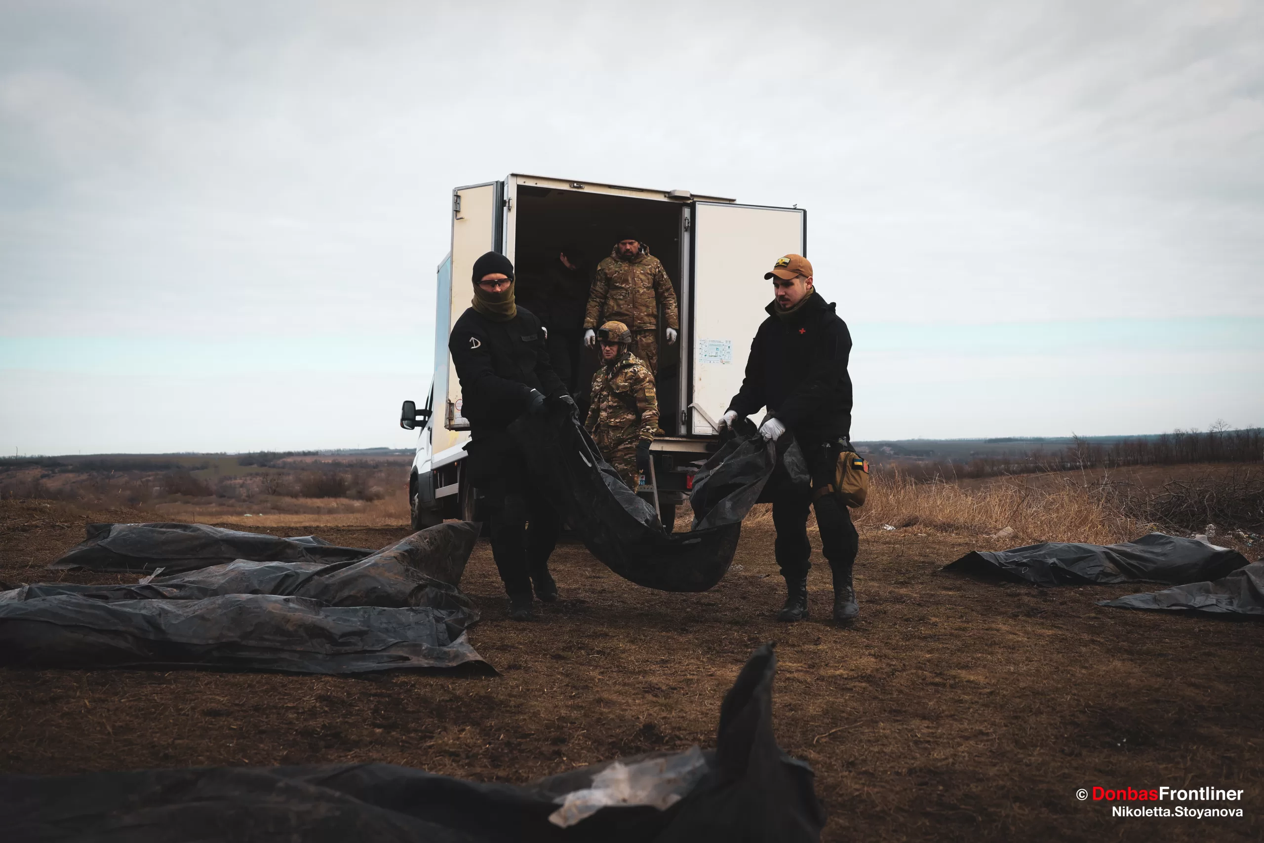 Пошуково-рятувальна група “Плацдарм” вивантажує тіла військовослужбовців з автівки.